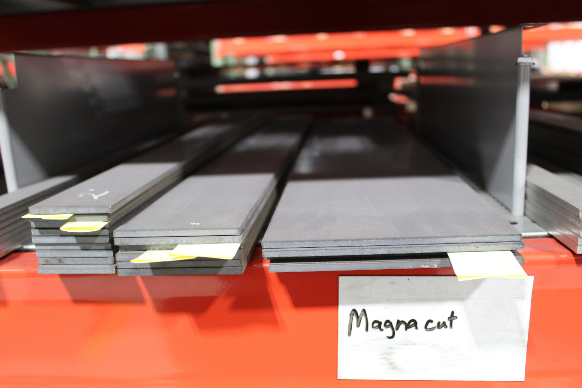 Warehouse rack displaying finished CPM MagnaCut inventory, highlighting knife steel collaboration between Niagara Specialty Metals and industry innovators