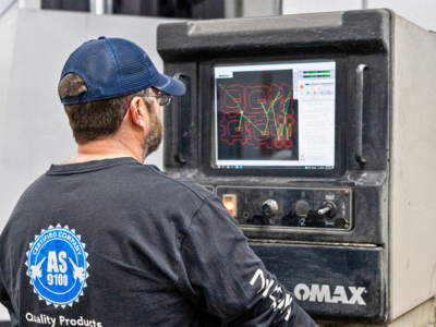 Niagara Specialty Metals worker monitoring laser control panel, showcasing advanced processing behind Niagara Specialty Metals knife steel