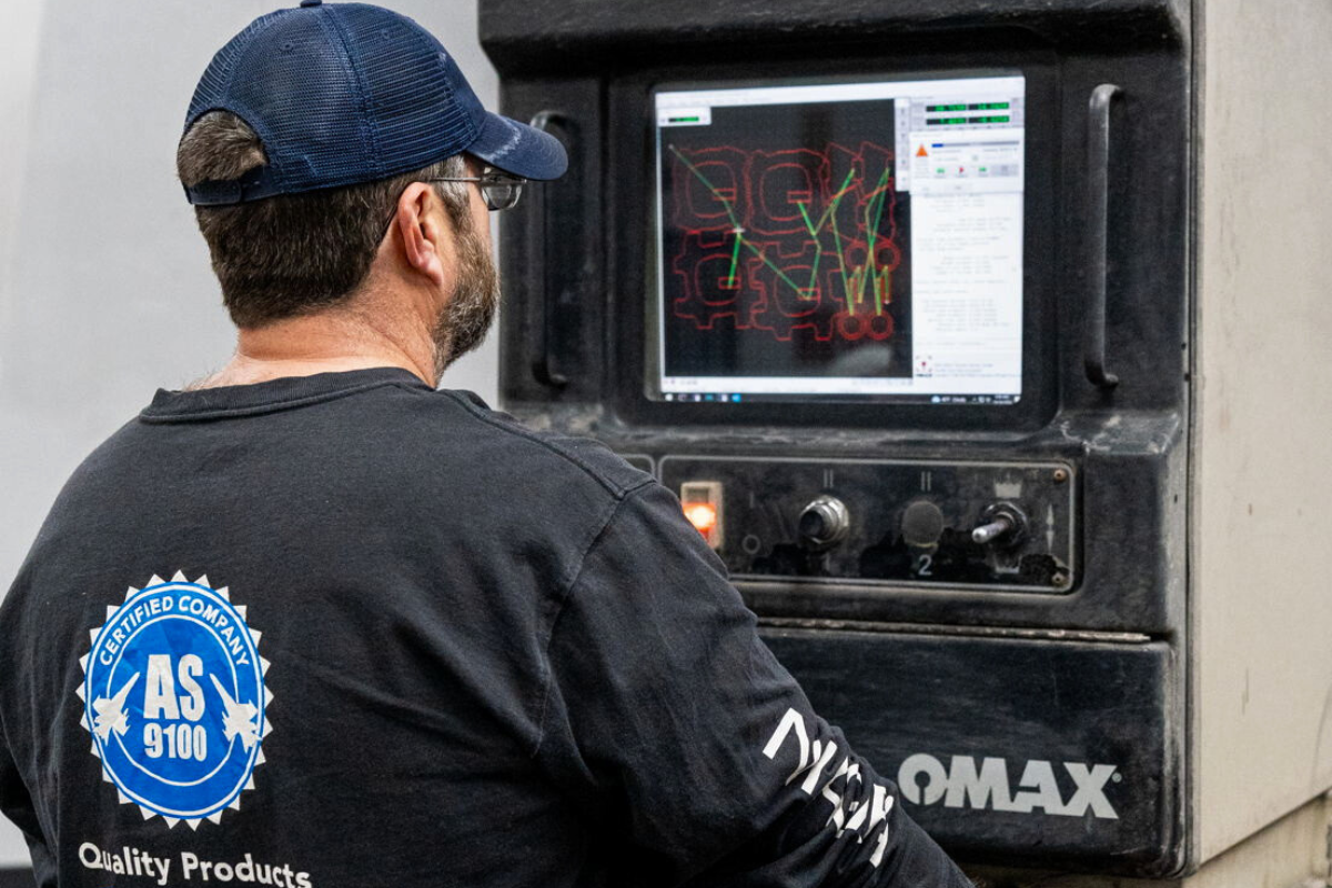 Niagara Specialty Metals worker monitoring laser control panel, showcasing advanced processing behind Niagara Specialty Metals knife steel