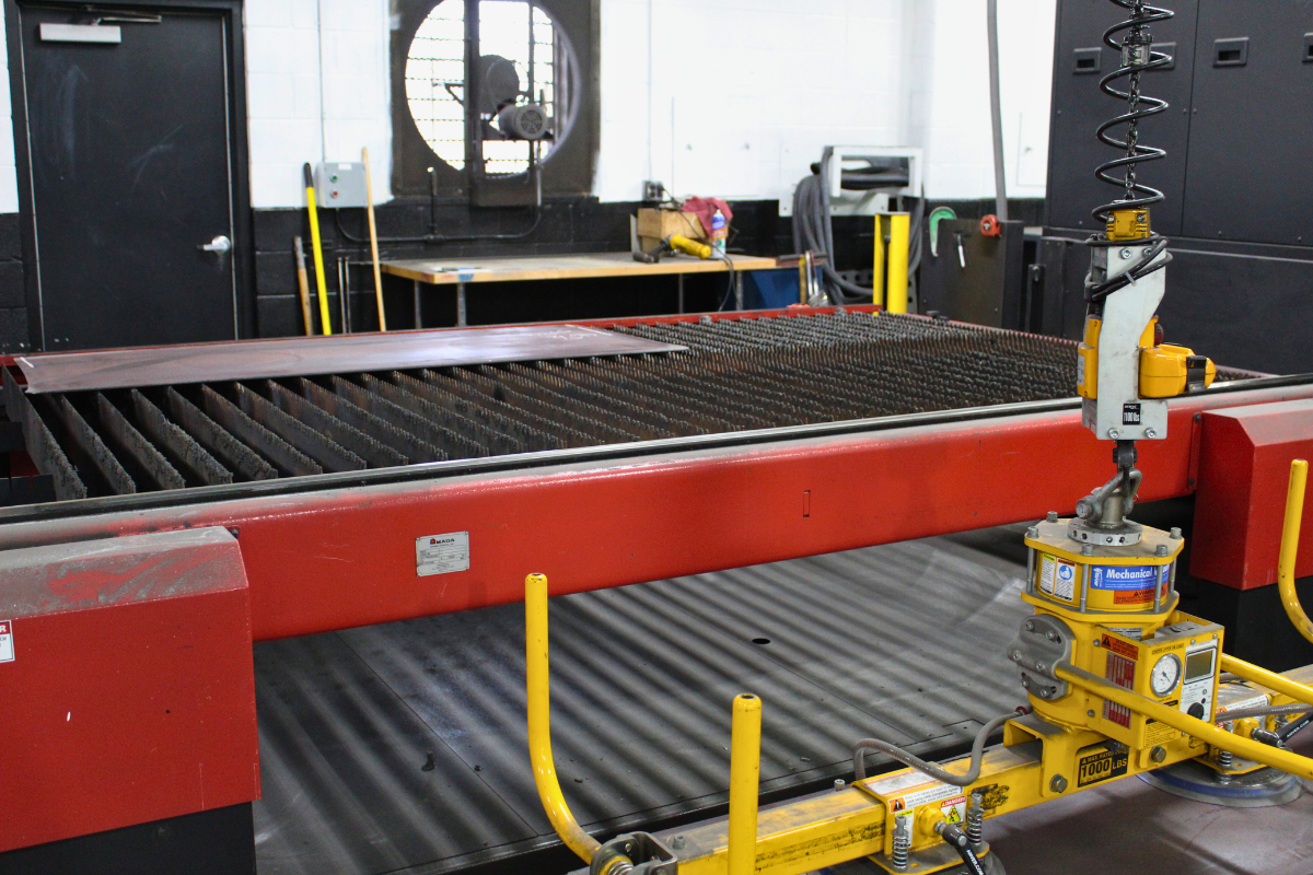 Robot operating near a laser machine at Niagara Specialty Metals highlighting advanced automation by a trusted knife steel supplier