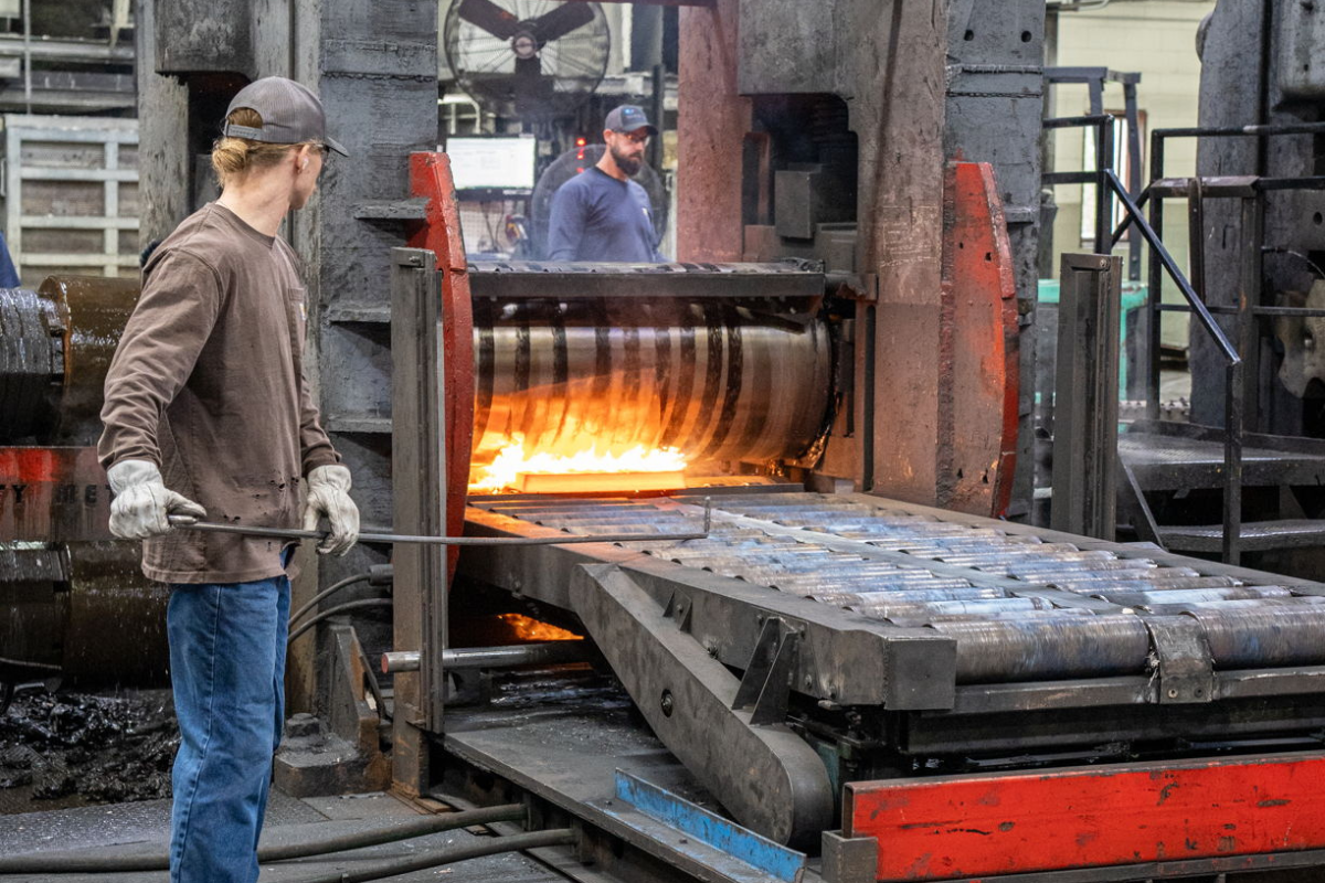 Niagara Specialty Metals worker operating a press in the plate mill while rolling out a specialty steel billet for aerospace, defense, industrial, and knife steel applications.