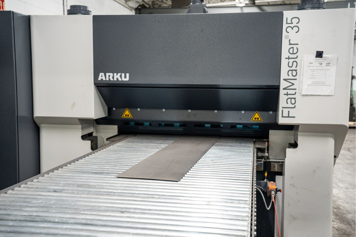 Specialty steel sheet being processed through the ARKU FlatMaster 35 at Niagara Specialty Metals, showcasing precision leveling and finishing for high-performance knife steel applications.