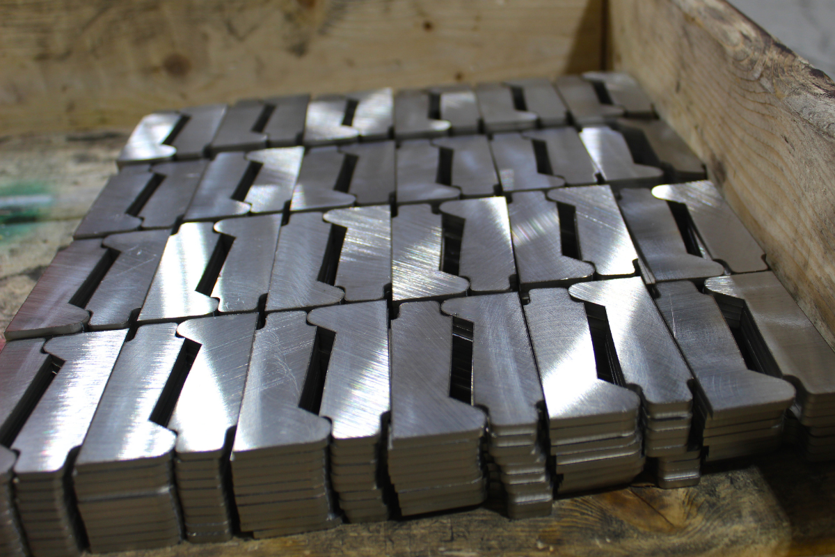 Large batch of precision-cut knife blade cutouts produced in-house, supporting knife steel education and performance-driven blade design