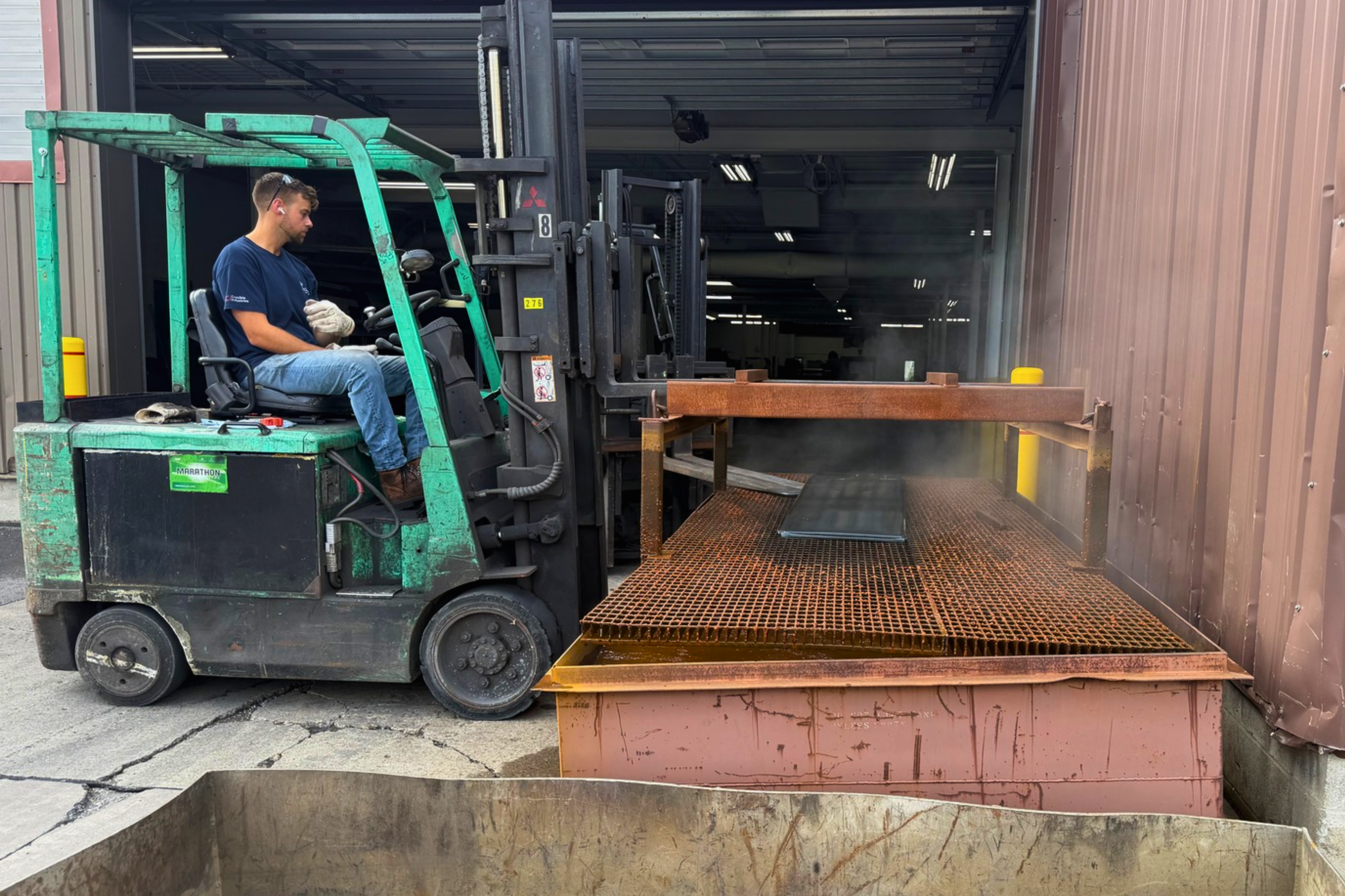 Metal annealing process at Niagara Specialty Metals with annealed specialty metal being removed from the water bath after furnace treatment