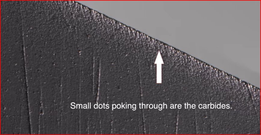 Magnified knife edge showing small carbide particles exposed along the cutting surface.