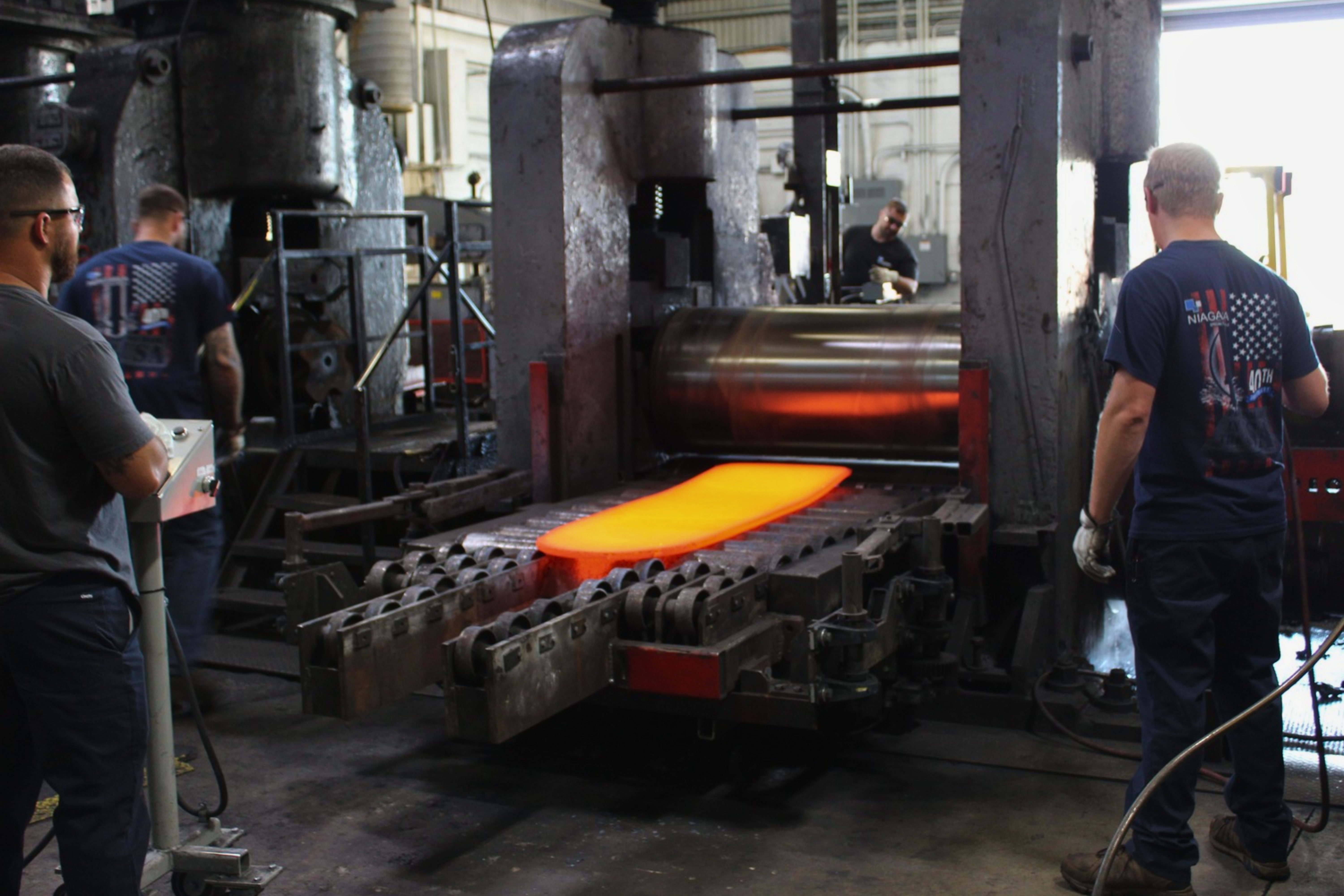Hot rolling process at Niagara Specialty Metals with a heated specialty metal plate moving through the plate mill